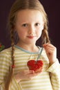 Young Girl Holding Heart Shaped Cookie In Studio