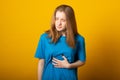 Girl holding her stomach and frowns. Teenage girl has a stomach ache. Female writhes in pain Royalty Free Stock Photo