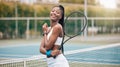 Young girl holding her tennis racket on the court. Portrait of a happy player ready for tennis practice. African Royalty Free Stock Photo