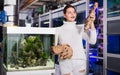 Young girl is holding large yellow-brown sandstone for aquarium decoration