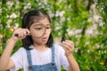 A young girl is holding a magnifying glass and looking at something Royalty Free Stock Photo