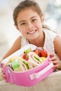 Young girl holding packed lunch in living room Royalty Free Stock Photo