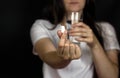 Young girl holding a pill in her hand and a glass of water, close-up Royalty Free Stock Photo