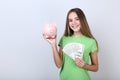 Girl holding piggybank and dollar banknotes Royalty Free Stock Photo