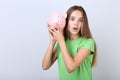 Girl holding pink piggybank Royalty Free Stock Photo