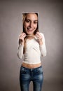 Young girl holding a smily portrait in front of her face