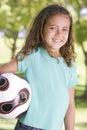 Young girl holding soccer ball outdoors smiling Royalty Free Stock Photo