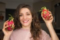 Young girl is holding two fresh ripe organic dragon fruits or pitaya, pitahaya. Exotic fruits, healthy eating concept Royalty Free Stock Photo