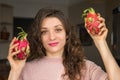 Young girl is holding two fresh ripe organic dragon fruits or pitaya, pitahaya. Exotic fruits, healthy eating concept Royalty Free Stock Photo