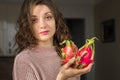 Young girl is holding two fresh ripe organic dragon fruits or pitaya, pitahaya. Exotic fruits, healthy eating concept Royalty Free Stock Photo