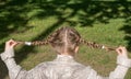 Young girl holding two hands pigtails