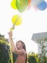 Young Girl Holding Up Balloons In Lawn Royalty Free Stock Photo