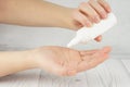 A young girl holds in her palms a small white bottle with cosmetic or perfume, drips into her palm Royalty Free Stock Photo