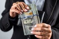 young girl holds a large sum of dollars in her hands and counts money in a black purse. Royalty Free Stock Photo