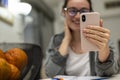 A young girl holds an online conference on a smartphone at home, sits at a table and laughs. Work, study, friends, sports, online