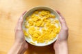 Young girl holds plate with milk and corn flakes Royalty Free Stock Photo