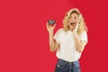 Girl on holiday with discount discount card for purchase in hands on red isolated background. Valentine`s Day, Valentine`s Day