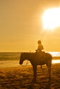 Young girl horseback riding on the beach at sunset Royalty Free Stock Photo