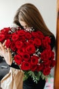 A young girl with a huge bouquet of red roses. Happy woman smelling flowers. Gifts for holidays and birthdays Royalty Free Stock Photo