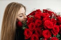 A young girl with a huge bouquet of red roses. Happy woman smelling flowers. Gifts for holidays and birthdays Royalty Free Stock Photo