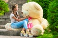 Young girl with a huge teddy bear in the park Royalty Free Stock Photo