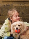Young girl hugging a little dog with ball Royalty Free Stock Photo