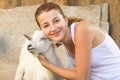 Young girl hugs  goat, pet with man Royalty Free Stock Photo