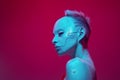 Young girl in image of futuristic cyborg robot with bare shoulders against pink studio background in neon light Royalty Free Stock Photo