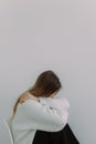 A young girl immersed in her thoughts sits on a chair on a white background, space for text. The concept of self-knowledge. Visual