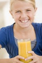 Young girl indoors drinking orange juice Royalty Free Stock Photo