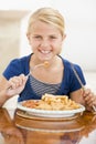 Young girl indoors eating fish and chips