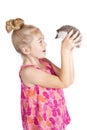 A young girl inspecting her pet hedgehog