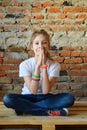 Young girl in jeans and white T-shirt is sitting on the floor and praying. Concept portrait of a pleasant friendly happy  teenager Royalty Free Stock Photo