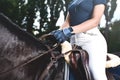 Young girl jockey trains horse to horse racing at summer. close-up photo Royalty Free Stock Photo