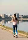 Young girl jogging in the morning. Woman working out on Lacul Morii or Windmill lake in Bucharest