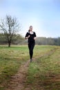 A young girl jogging in a park