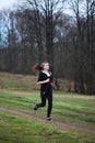 A young girl jogging in a park