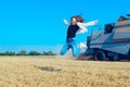 Young girl jumping, combine, wheat field. Happy teenage girl outdoor. Royalty Free Stock Photo