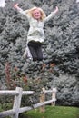 Young girl jumping from a fence Royalty Free Stock Photo