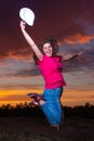 Young girl jumping from happiness up against evening sky Royalty Free Stock Photo