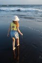 Young girl jumping and running waves at beach on sunset time.