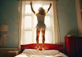 a young girl jumping on the top of her bed Royalty Free Stock Photo