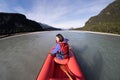 Young girl kayaking down a dart river of New Zealand