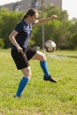 Young girl kicking soccer ball on field Royalty Free Stock Photo