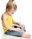 Young girl kid sitting reading learning drawing on digital tablet touch screen pad with pencil Royalty Free Stock Photo