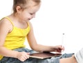 Young girl kid sitting reading learning drawing on digital tablet touch screen pad with pencil Royalty Free Stock Photo