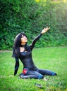 Young girl kneels and stretches out his hand to the sky.