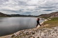 A young girl laughs and joyfully jumps on a rock near the lake. Royalty Free Stock Photo