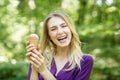 A young girl laughs and keeps ice cream. Concept of lifestyle, summer, food, vacation. Royalty Free Stock Photo