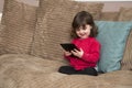 Young girl laughs at tablet Royalty Free Stock Photo